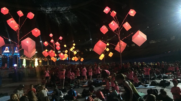 Des enfants au Stade olympiques entourés d'arbres auxquels sont accrochés des cubes d'énergie illuminés. Des enfants au Stade olympiques entourés d'arbres auxquels sont accrochés des cubes d'énergie illuminés.