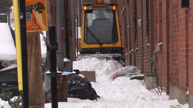Une chenillette sur un trottoir encombré de déchets