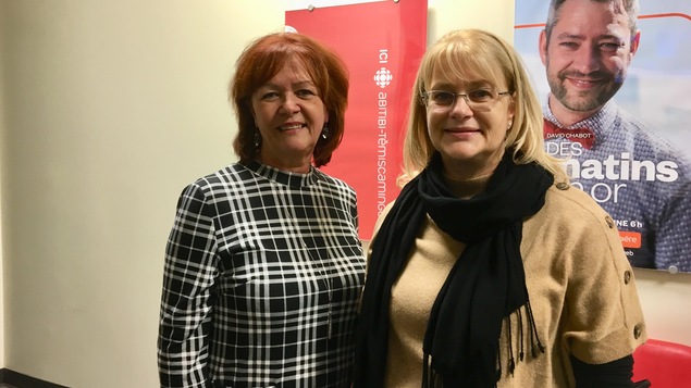 Diane Dallaire et Claire Bolduc devant l'affiche d'ICI Abitibi-Témiscamingue dans notre station.