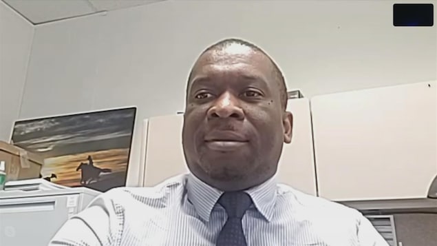 Un homme de couleur noire portant une cravate dans un bureau.
