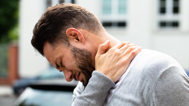 Un homme se masse le cou en raison de la douleur. Un homme se masse le cou en raison de la douleur.
