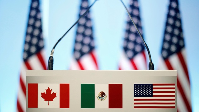 Les drapeaux du Canada, du Mexique et des États-Unis sont vus sur un lutrin avant une conférence de presse conjointe sur la clôture de la septième ronde de négociations de l'ALENA à Mexico.