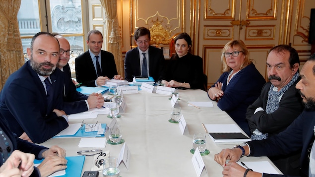 Plusieurs personnes sont assises autour d'une table.