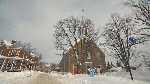 Église de Saint-Élie-de-Caxton en hiver avec un lutin sur un poteau
