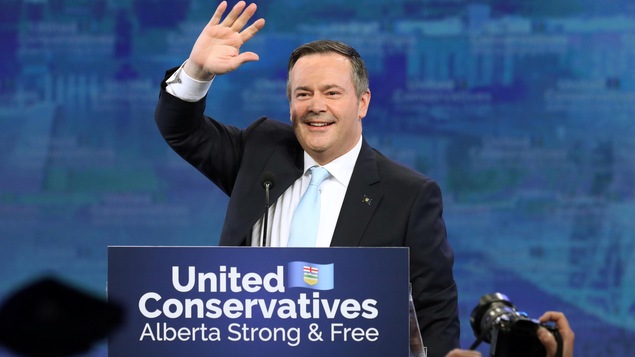 Jason Kenney lève le bras pour saluer ses partisans.
