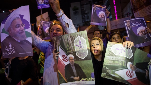 Des partisans du président sortant Hassan Rohani brandissent des affiches électorales. Des partisans du président sortant Hassan Rohani brandissent des affiches électorales.