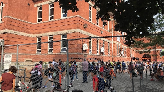 Des élèves du primaire dans une cour d'école.