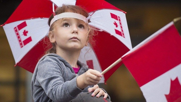 Une petite fille qui tient un drapeau du Canada Une petite fille qui tient un drapeau du Canada