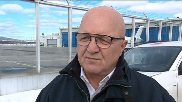 Éric Houde devant une voiture.