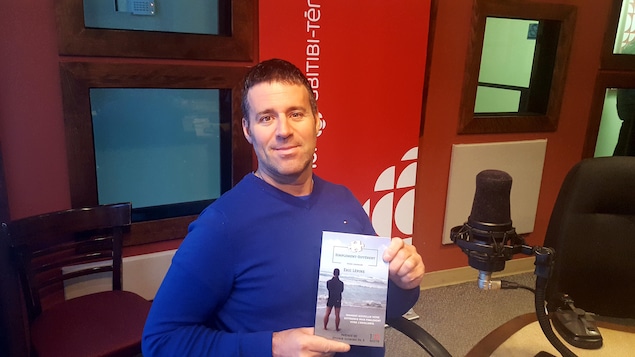 L'auteur, Éric Lépine, dans le studio de Radio-Canada en Abitibi-Témiscamingue avec son livre Simplement Différent.