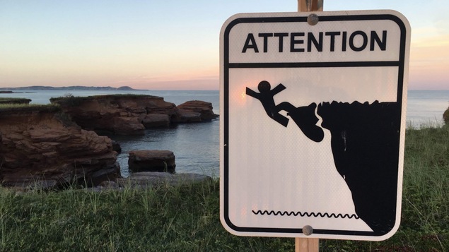 Affiche de mise en garde près des caps rocheux aux Îles-de-la-Madeleine.