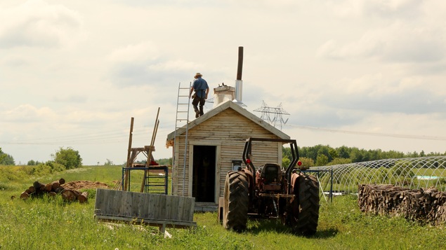 Le tracteur et un homme sur le toit d'une cabane. Le tracteur et un homme sur le toit d'une cabane.