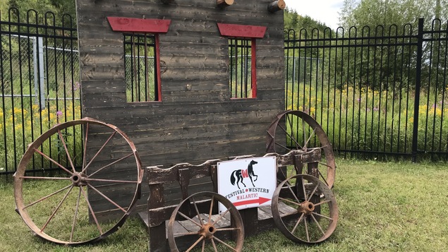 Une décoration de style western avec une affiche indiquant Festival western de Malartic.
