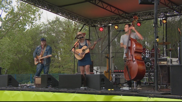 Trois musiciens jouent de la musique sur une scène pour la fête fransaskoise. Trois musiciens jouent de la musique sur une scène pour la fête fransaskoise.