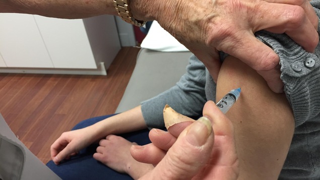 Une jeune fille se fait administrer un vaccin contre la fièvre jaune. Une jeune fille se fait administrer un vaccin contre la fièvre jaune.