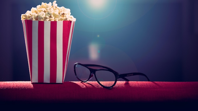 Du popcorn et des lunettes sur un fauteuil.