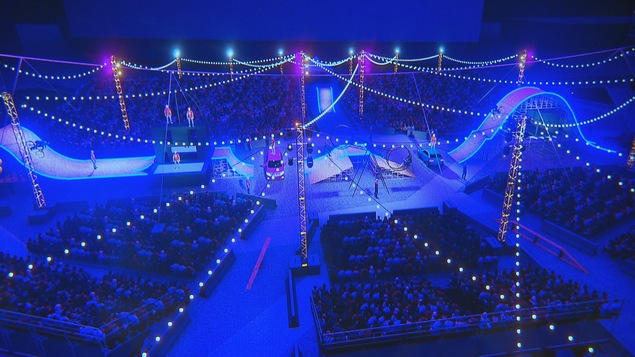 Un grand espace avec du public et des installations de cirque.