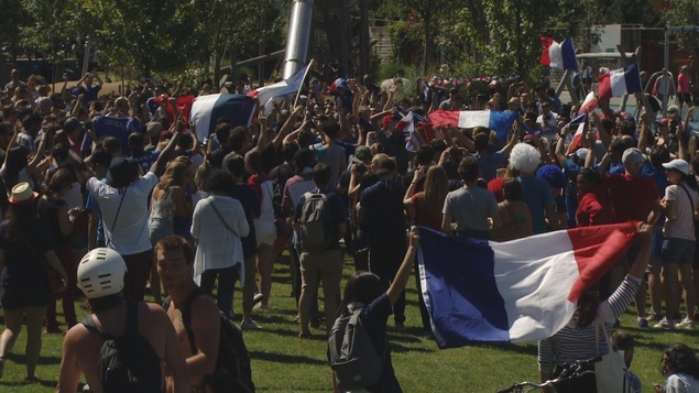 Des gens dans un parc avec des drapeaux bleu-blanc-rouge.