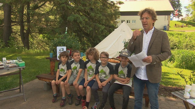 Fred Pellerin et des enfants assis sur un banc