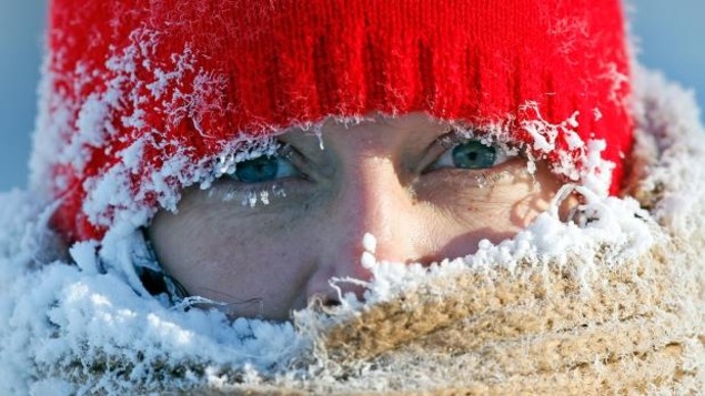 Une femme avec une tuque glacée et de la glace sur ses cils.
