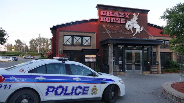 Une voiture de la police d'Ottawa est garée devant le bar Crazy Horse. Une voiture de la police d'Ottawa est garée devant le bar Crazy Horse.