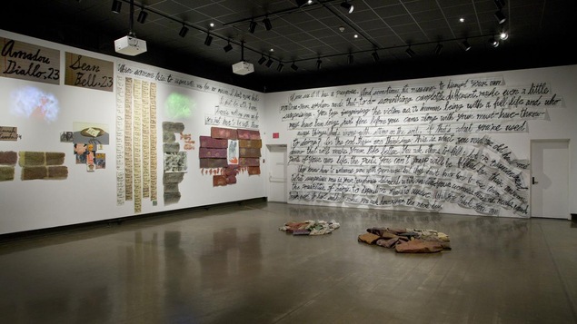 Grande salle avec de grosses écritures sur les murs, des fragments de papiers. Au sol, quelques vieux vêtements regroupés en deux tas.