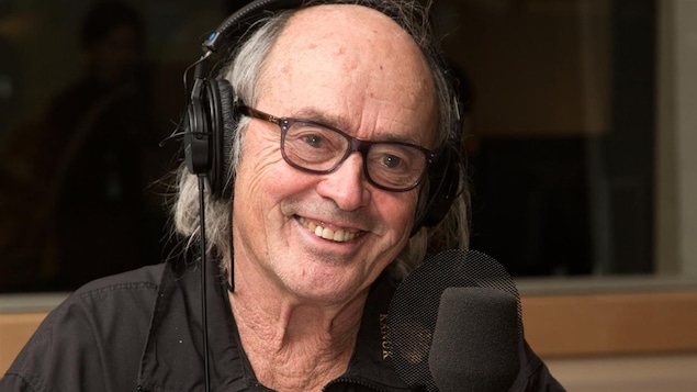 Georges Brossard, un casque d'écoute sur la tête.
