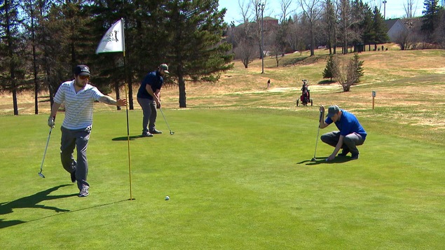 Des golfeurs se préparent à faire leurs coups roulés.