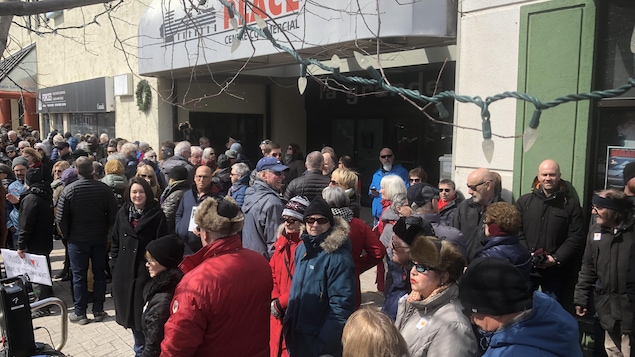 Des dizaines de personnes devant l'immeuble du centre commercial La Grande Place.