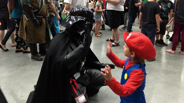 Un enfant déguisé en Mario Bros tape dans la main de Darth Vader Un enfant déguisé en Mario Bros tape dans la main de Darth Vader