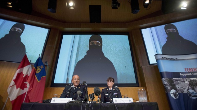 Des agents de la GRC devant une image de la vidéo d'Aaron Driver Des agents de la GRC devant une image de la vidéo d'Aaron Driver