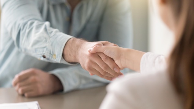 Un homme et une femme échangent une poignée de main