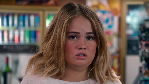 L'actrice Debby Ryan est dans un supermarché et regarde quelque chose qui la rend triste dans la série «Insatiable».