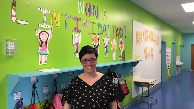 Une enseignante pose dans le couloir d'une école primaire.