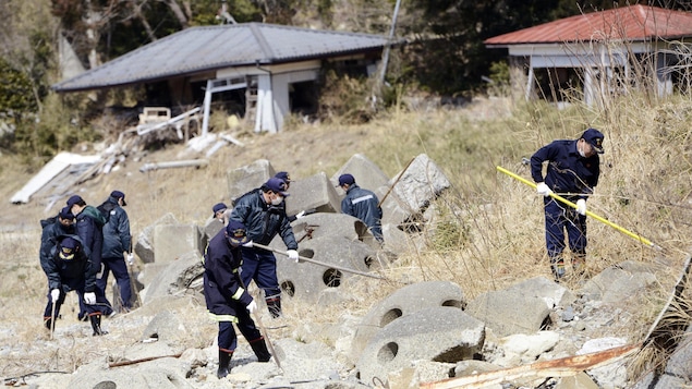 Des policiers procèdent à des opérations de recherche à Tomioka dans la région de Fukushima. Des policiers procèdent à des opérations de recherche à Tomioka dans la région de Fukushima.