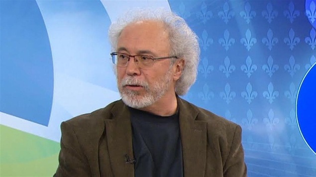 Jean-Pierre Charbonneau portant un veston et regardant vers sa droite.