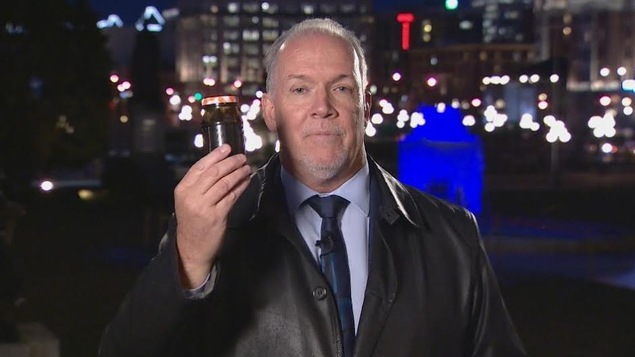 Le chef du Nouveau Parti démocratique de la Colombie-Britannique, John Horgan, tient un bocal rempli de bitume. Le chef du Nouveau Parti démocratique de la Colombie-Britannique, John Horgan, tient un bocal rempli de bitume.