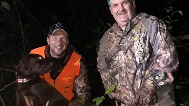 Jonathan Doire tient son chien Ally et André Gaudet tient les bois de l'orignal qu'il a abattu.