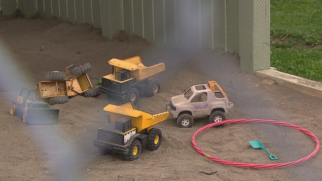 Des jouets dans un bac à sable pour illustrer la maltraitance envers les enfants