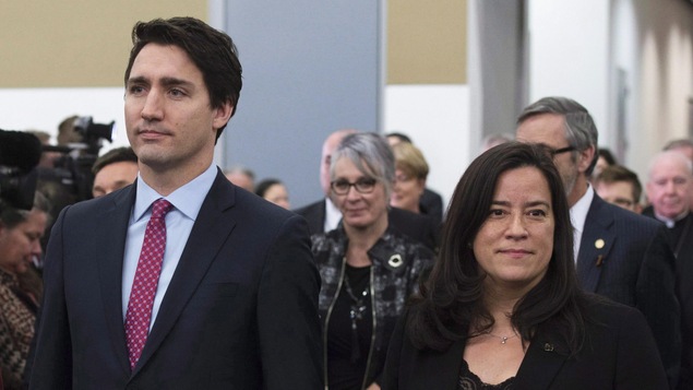 Justin Trudeau et Jody Wilson-Raybould se tiennent côte à côte, mais regardent dans des directions opposées.