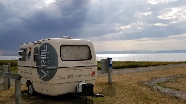 Roulotte Vrille Art Actuel stationnée le long du fleuve Saint-Laurent avec vue sur la rive opposée