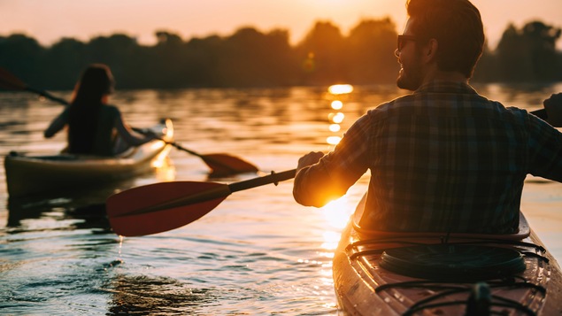 Une homme admire le coucher de soleil pendant une randonnée en kayak.