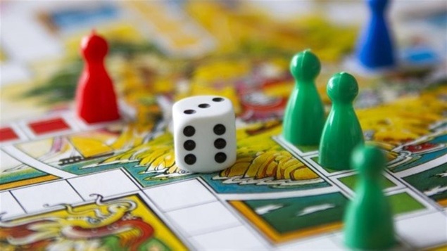 On voit les pions et un dé d'un jeu de société
