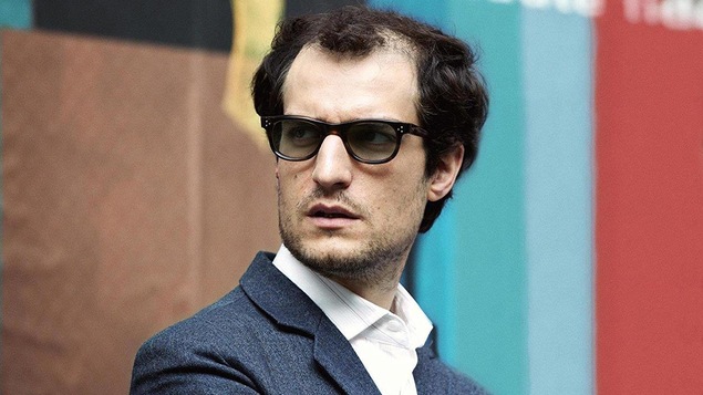 Louis Garrel regarde vers sa droite dans une scène du film <i>Le redoutable</i> Louis Garrel regarde vers sa droite dans une scène du film <i>Le redoutable</i>
