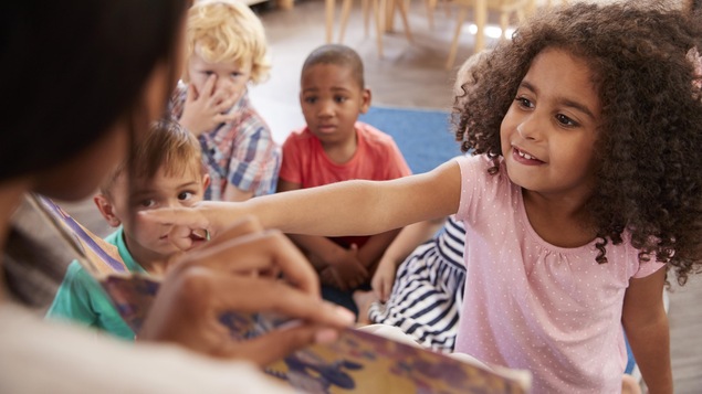 Des enfants sont rassemblés devant un livre