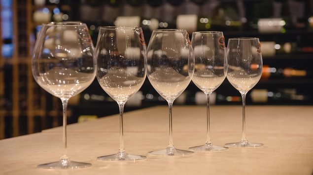 Cinq verres à vin sur une table.