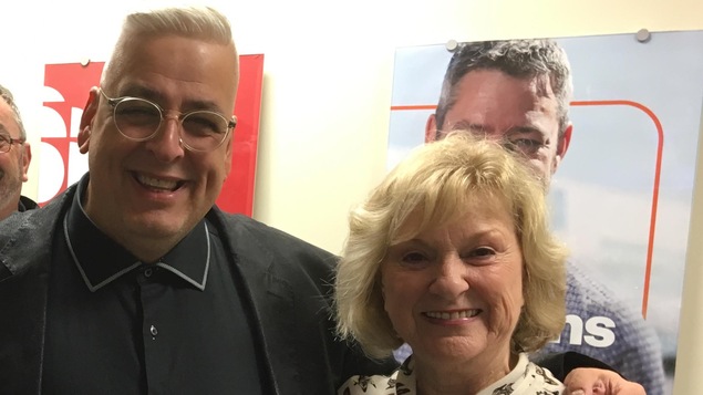 Denis Queen, alias Lit Queen, et Claudette Dion posent devant une affiche de Radio-Canada.