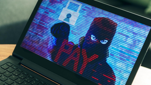 Un écran d'ordinateur montre un pirate informatique qui exige un paiement. Un écran d'ordinateur montre un pirate informatique qui exige un paiement.
