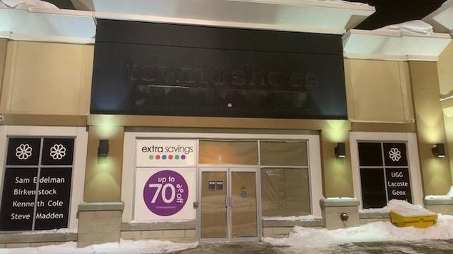 Devanture d’un ancien magasin de souliers, le soir.