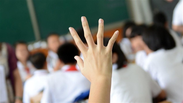 Un élève lève la main en classe